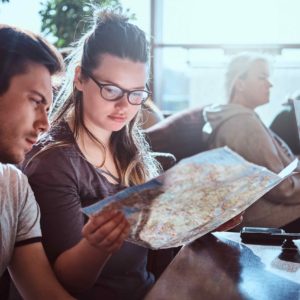 portrait-young-couple-sitting-outdoor-caf-planning-itinerary-their-journey
