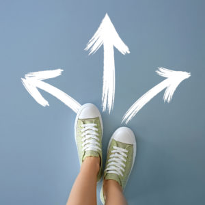 Woman,Standing,On,Color,Background,With,Arrows,Pointing,In,Different Affrontare i momenti di passaggio